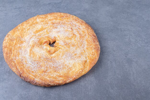 Poudre de sucre sur du pain sur une table en marbre.