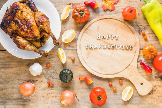 Poulet au four près de légumes et planche à découper