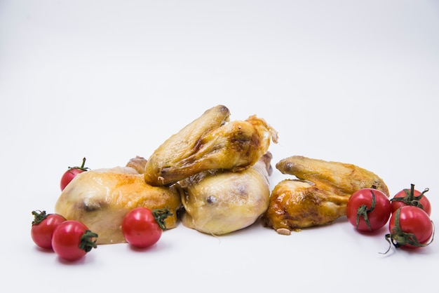 Poulet cuit au four avec tomates contre isolé sur fond blanc