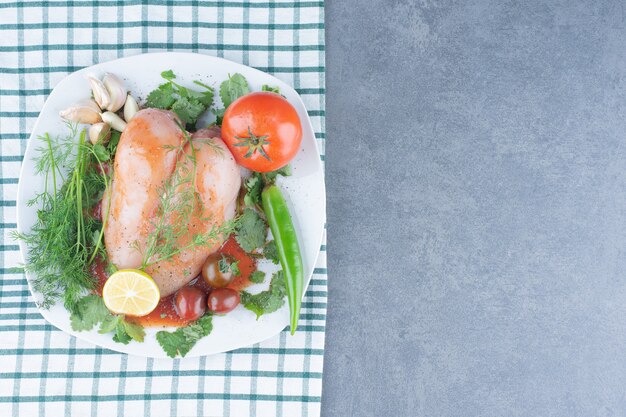 Poulet entier mariné sur assiette avec légumes.