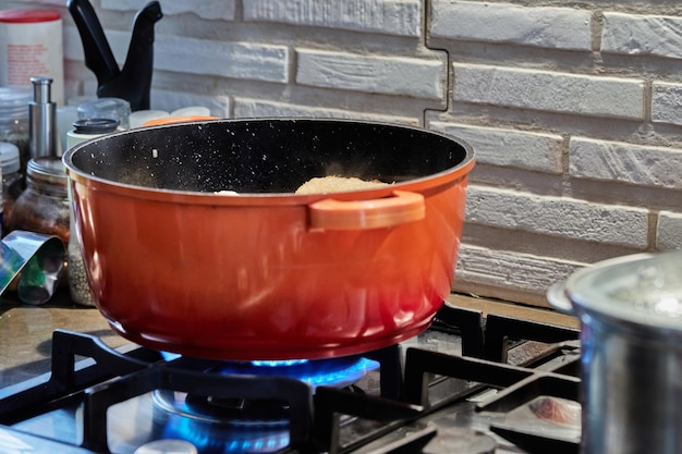 Le Poulet Est Cuit Dans Une Marmite Sur Une Cuisinière à Gaz Dans La Cuisine Photo Premium