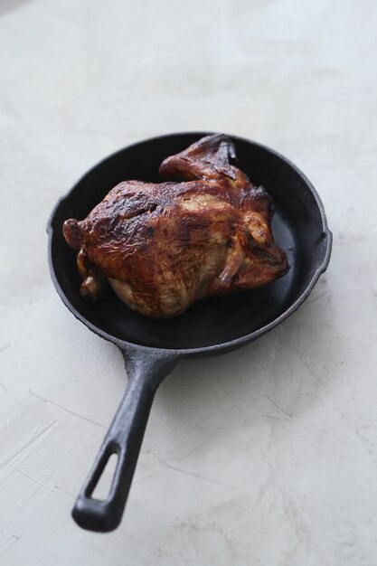 Poulet frit dans une poêle noire