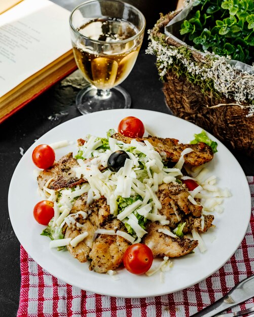 Poulet frit avec fromage râpé tomates laitue et olive