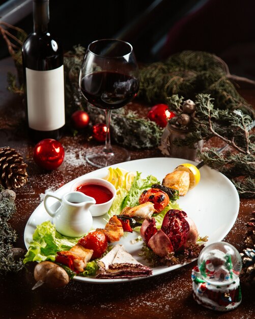 Poulet frit et légumes sur bâton avec verre de vin rouge