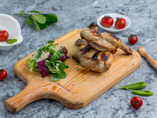 poulet frit avec des légumes sur une planche de bois
