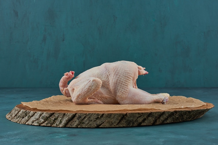 Photo gratuit poulet sur une planche de bois.