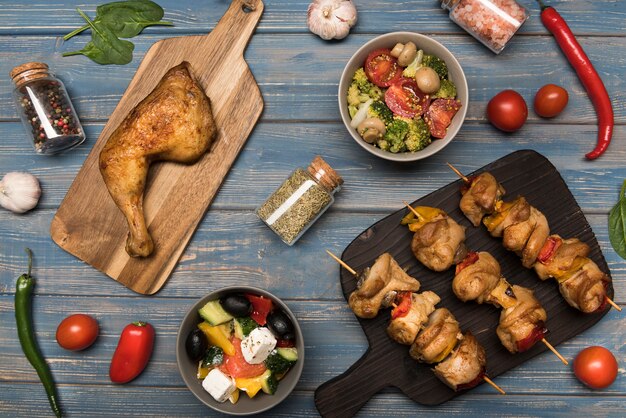 Poulet plat et brochettes sur planche de bois et ingrédients avec ingrédients