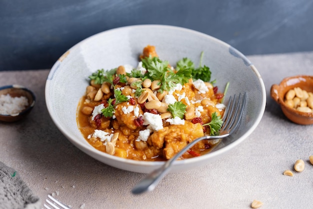 Photo gratuite poulet en sauce curry servi dans un bol avec des bâtonnets sur la table en gros plan