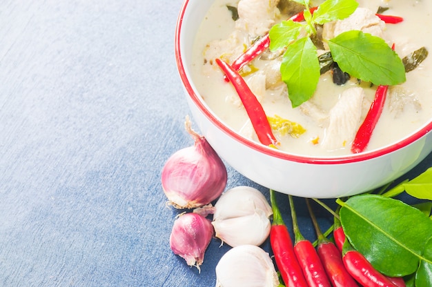 Poulet vert au curry avec ingrédient épicé cru cuisine traditionnelle thaïlandaise sur fond bleu clair