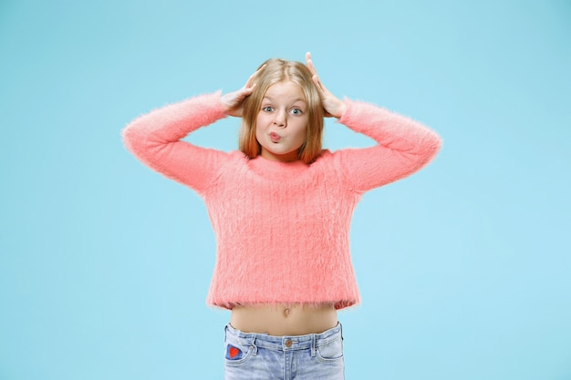 Photo gratuite pourquoi donc. beau portrait de femme demi-longueur sur fond de studio bleu à la mode. jeune adolescente émotive surprise, frustrée et déconcertée. émotions humaines, concept d'expression faciale.