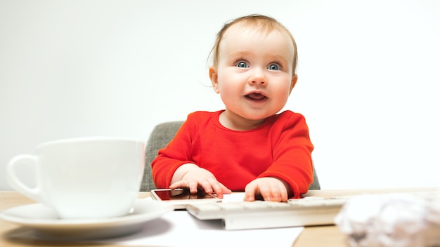 Premier Sms. Bébé Enfant Fille Assise Avec Clavier D'ordinateur Moderne Ou Ordinateur Portable En Studio Blanc