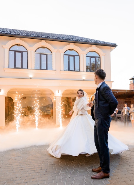 Première danse sur un couple de mariage amoureux en plein air entouré d'effets pyrotechniques