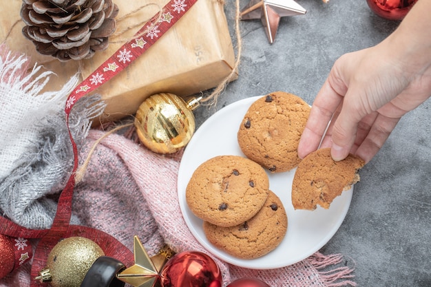 Prendre un morceau de biscuit à l'avoine d'une soucoupe blanche