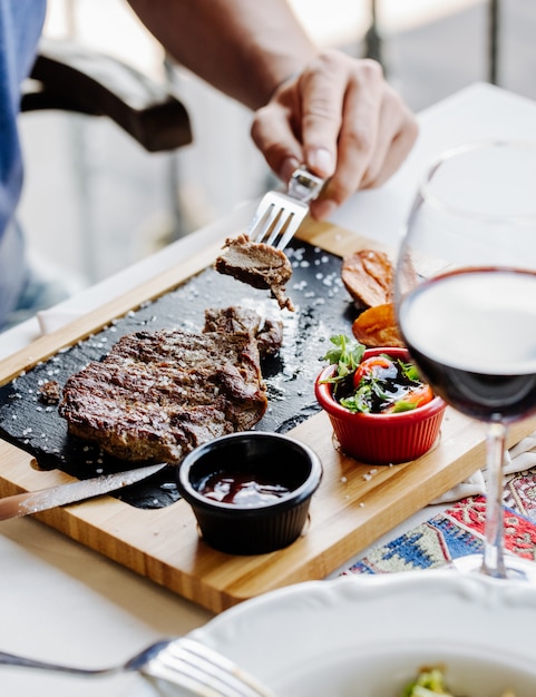 Prendre un morceau de steak avec une fourchette.