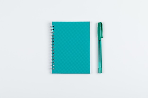 Prendre des notes et le concept de cahier avec un stylo sur un fond blanc à plat. image horizontale