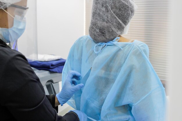 Preparaciãn de los medicos para la operaciãn quirúrgica en el hospital durante el brote del coronavirus - medico preparãndose para operar
