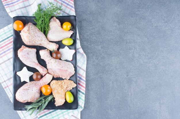 Photo gratuite préparation pour le dîner avec assiette de cuisses de poulet crues.