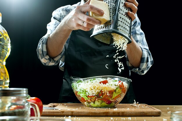 Préparer la salade. Femme chef coupe des légumes frais. Processus de cuisson. Mise au point sélective