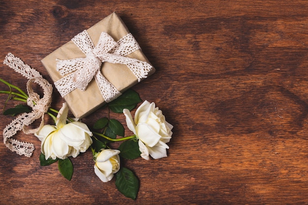 Photo gratuite présent à égalité avec napperon et bouquet de rose