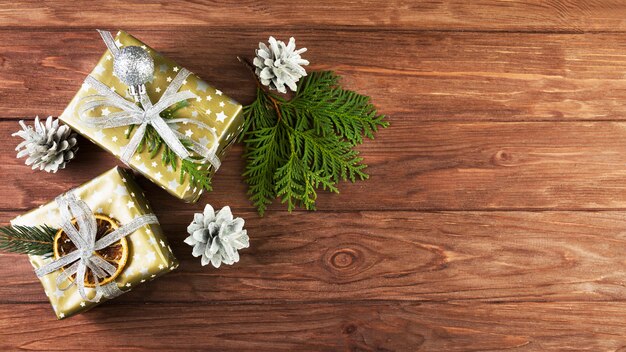 Présenter des boîtes dans des enveloppes de Noël près de chicots et de branches de conifères