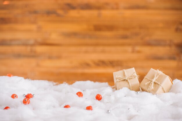 Présenter des boîtes sur la neige décorative près du mur