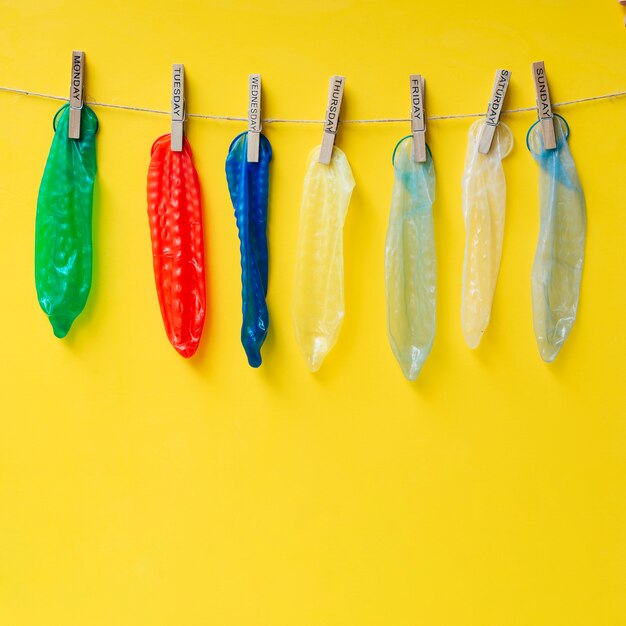 Préservatifs colorés suspendus sur une corde à linge