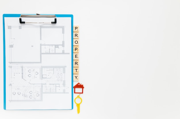 Photo gratuite presse-papiers blueprint avec des blocs de propriété et clé de la maison sur fond blanc