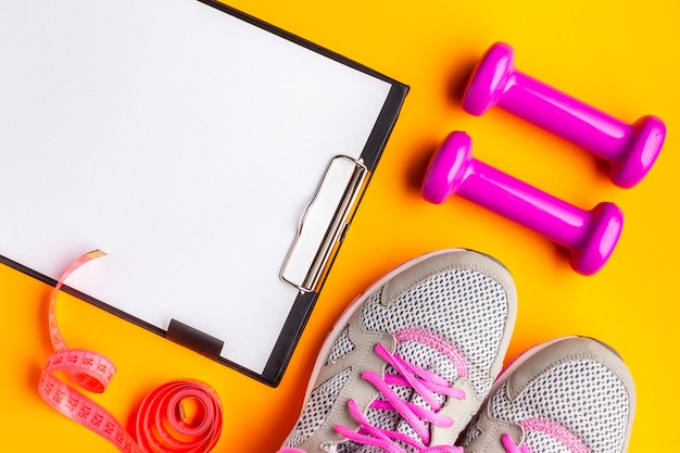 Photo gratuite presse-papiers avec chaussures sur fond jaune