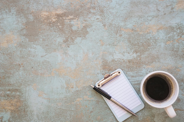 Presse-papiers miniature avec stylo et tasse à café sur fond rustique