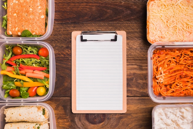 Photo gratuite presse-papiers vierge vue de dessus avec des boîtes à lunch