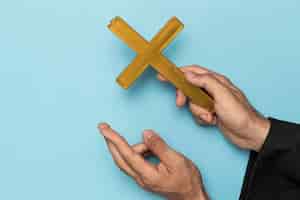 Photo gratuite prêtre avec un doigt croisé et une croix en bois