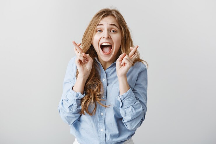 Photo gratuit prie là où on l'entend, la fille remporte la première place. excité femme européenne heureuse aux cheveux blonds, levant les doigts croisés et criant de bonheur et de surprise, être heureux, triomphant de nouvelles positives