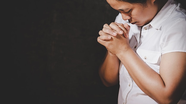 Photo gratuite prière de crise de la vie chrétienne à dieu. femme priez pour que dieu bénisse de souhaiter une vie meilleure. mains de femme priant dieu avec la bible. demandant pardon et croire en la bonté.