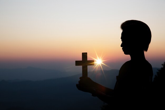 Prière spirituelle mains sur le soleil brille avec beau coucher de soleil floue