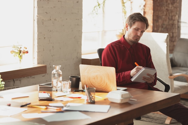 Prise de notes. Entrepreneur caucasien, homme d'affaires, gestionnaire essayant de travailler au bureau.