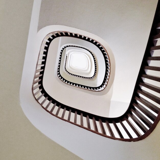 Prise de vue en contre-plongée d'un escalier en colimaçon moderne en blanc