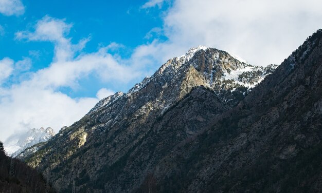 Prise de vue en contre-plongée de hautes montagnes rocheuses sous un ciel nuageux