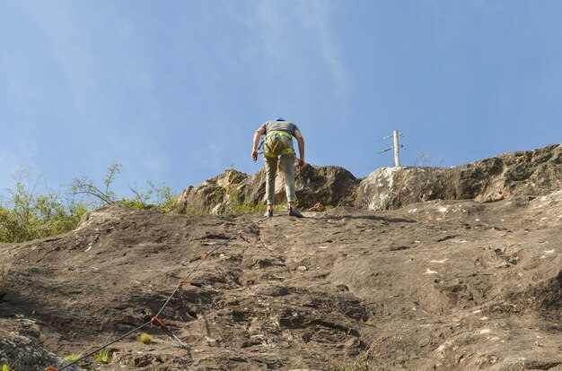 Prise de vue en contre-plongée d'un jeune randonneur escaladant des montagnes