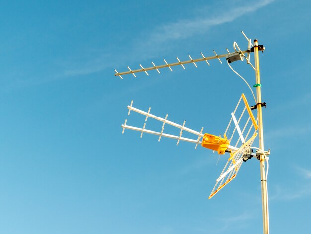 Prise de vue à faible angle d'une antenne de télévision capturée par une journée ensoleillée avec un ciel clair