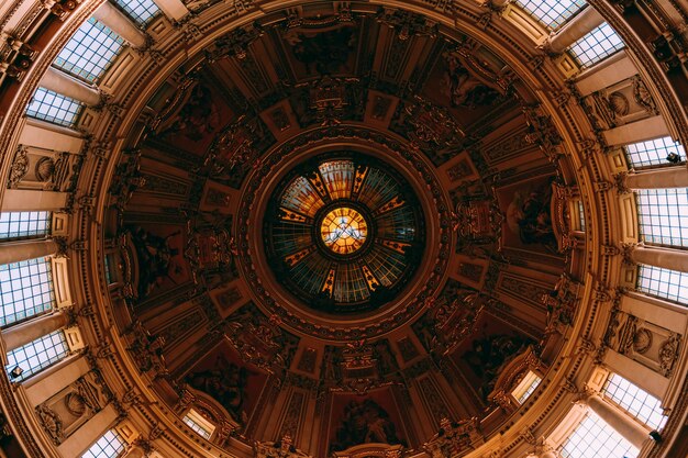 Prise de vue à faible angle de la belle peinture et fenêtres sur un plafond dans un immeuble ancien