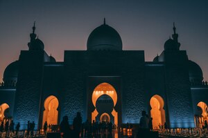 Prise de vue en faible angle d'une grande mosquée à abu dhabi avec des lumières rougeoyantes à l'intérieur d'un bâtiment