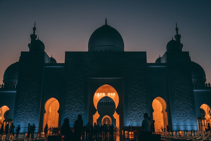 Photo gratuit prise de vue en faible angle d'une grande mosquée à abu dhabi avec des lumières rougeoyantes à l'intérieur d'un bâtiment