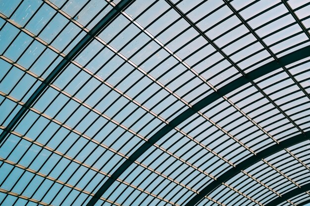 Prise de vue à faible angle d'un toit en verre d'un bâtiment moderne sous le ciel bleu