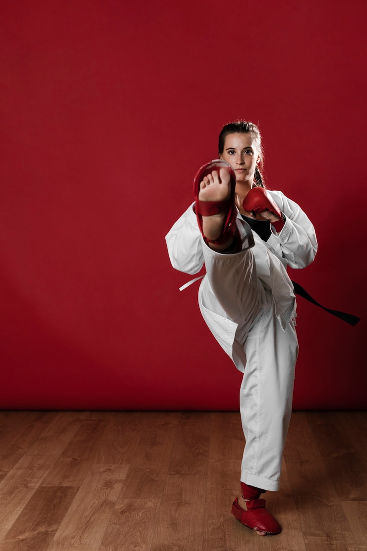Photo gratuit prise de vue d'une femme à la ceinture noire et kimono pratiquant le karaté