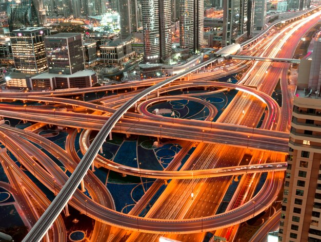 Prise de vue en grand angle d'une autoroute éclairée avec intersections à plusieurs niveaux dans une mégapole la nuit