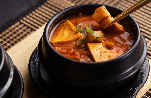 Prise de vue en grand angle d'un bol de délicieuse soupe de viande et de légumes sur une table en bois