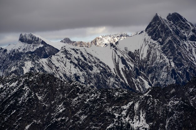 Prise de vue en grand angle de la chaîne de montagnes alpines sous le ciel nuageux