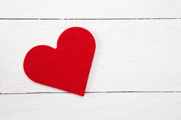 Prise de vue en grand angle d'un coeur de papier rouge isolé sur une surface en bois blanc