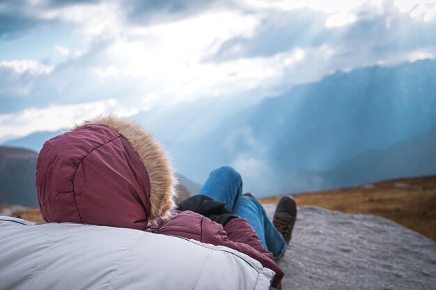 Prise de vue en grand angle d'un couple allongé au sommet d'une montagne