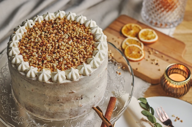 Prise de vue en grand angle d'un délicieux gâteau de Noël blanc avec des noix et mandarine